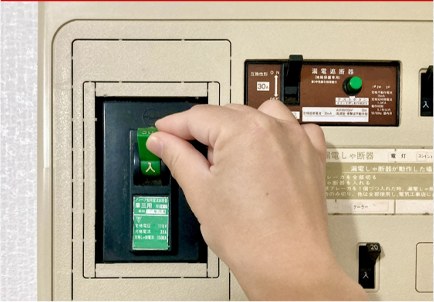 漏電ブレーカーを操作する手